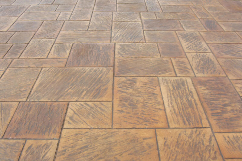 Terracotta concrete is colored by dry granular pigments and stamped with a rustic stone pattern