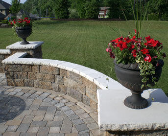 Image of light colored stone veneer wall caps and post caps on an outdoor stone wall. Reading Rockcast stone sold by Westview Concrete.
