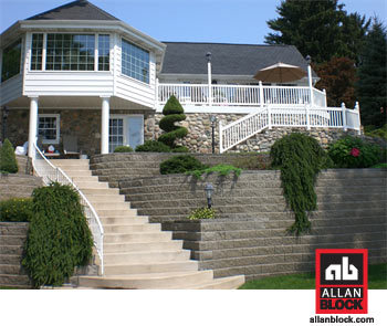 Image of a homes backyard with stairs leading up to the house and a retaining wall around the yard and lining the stariway.