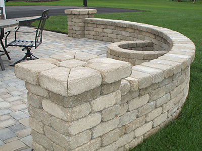 Image of a grey white bench stone wall with short posts on either end.